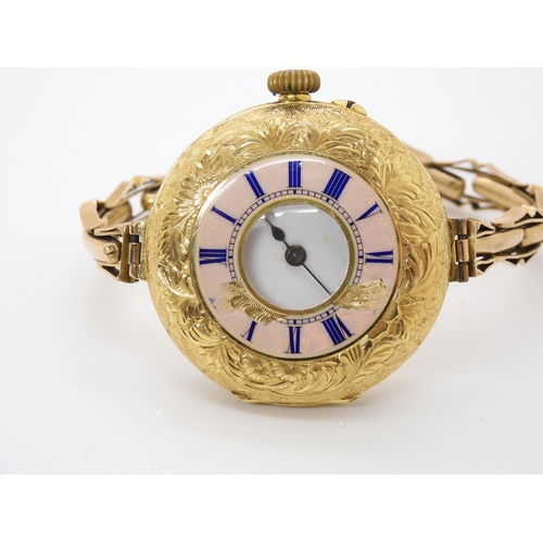 906 - AN 18K GOLD HALF HUNTER WRISTWATCHthe decorative pink guilloche enamel chapter ring with blue enamel... 