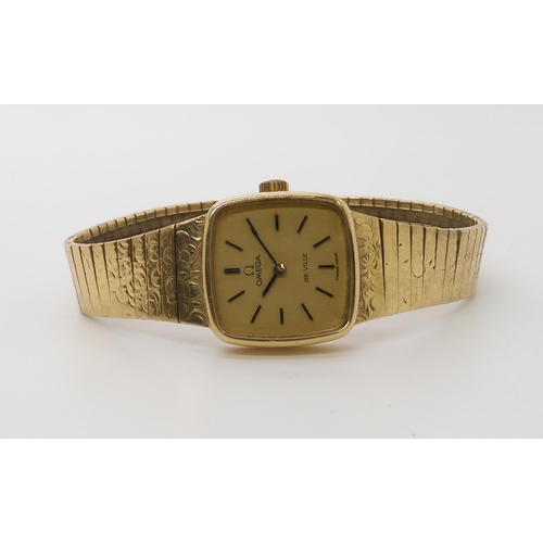 922 - A 9CT GOLD LADIES OMEGA DE VILLEwith integral textured strap. Dimensions of the case 2cm x 2cm, leng... 