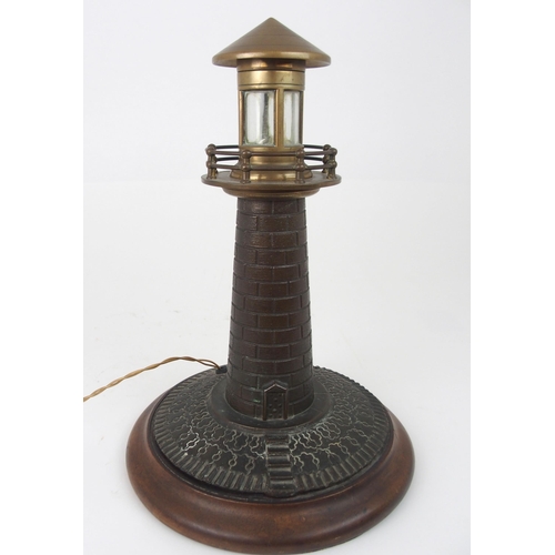 608 - A VINTAGE CAST BRASS LIGHTHOUSE TABLE LAMPfitted for electricity, on circular wooden base, 37cm high... 