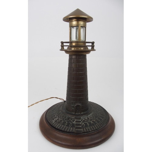 608 - A VINTAGE CAST BRASS LIGHTHOUSE TABLE LAMPfitted for electricity, on circular wooden base, 37cm high... 