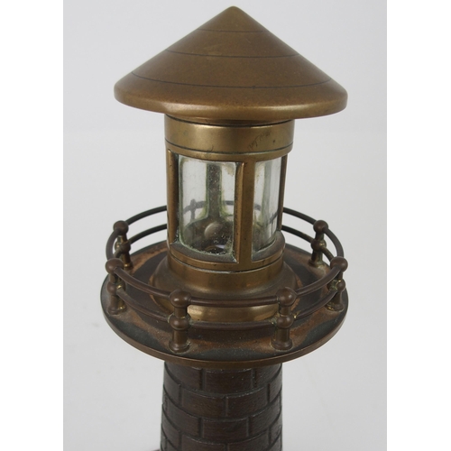 608 - A VINTAGE CAST BRASS LIGHTHOUSE TABLE LAMPfitted for electricity, on circular wooden base, 37cm high... 