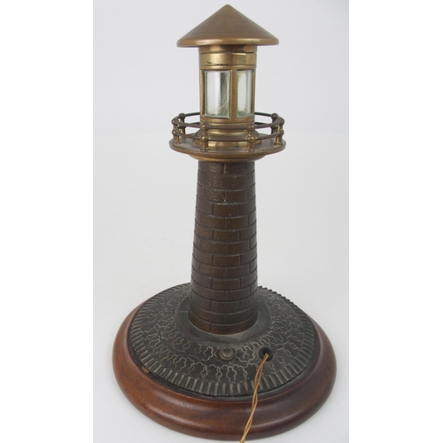 608 - A VINTAGE CAST BRASS LIGHTHOUSE TABLE LAMPfitted for electricity, on circular wooden base, 37cm high... 