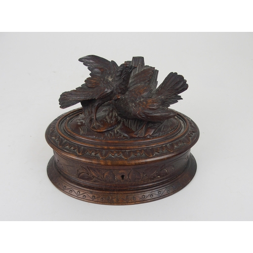 615 - A VICTORIAN OVAL BLACK FOREST JEWELLERY CASKETthe lid surmounted by carved birds, 21cm wide... 