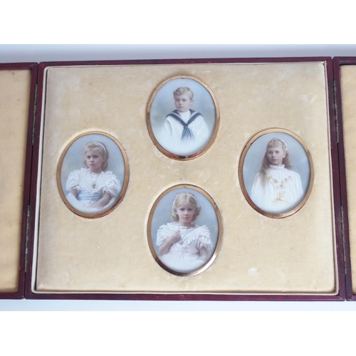 652 - A FAMILY GROUP OF PAINTED OVAL PORTRAIT MINIATUREScomprising three girls and one boy, 7 x 5.5cm, in ... 