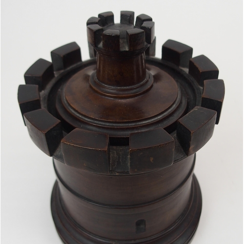 666 - A MAHOGANY TURRET TOBACCO JARof circular form with castellations, removable lid, 20cm high... 