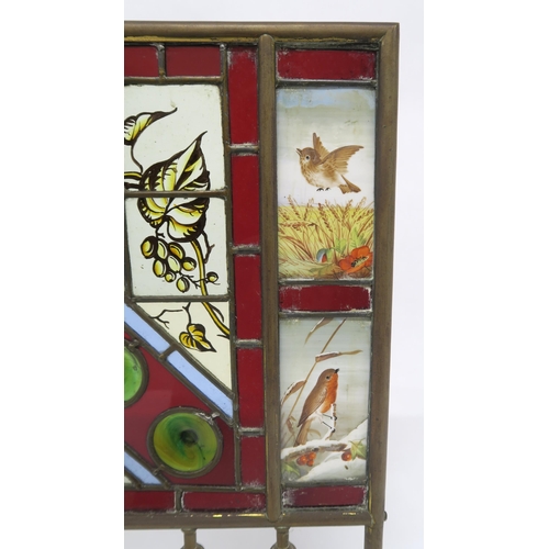 2 - A VICTORIAN BRASS AND STAINED GLASS FIRE SCREENwith four hand painted inset panels depicting seasona... 