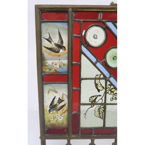 2 - A VICTORIAN BRASS AND STAINED GLASS FIRE SCREENwith four hand painted inset panels depicting seasona... 