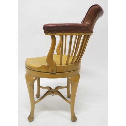39 - A CAPTAINS BEECH REVOLVING SHIPS ARMCHAIR CHAIRwith brown vinyl upholstered comb back on stretchered... 