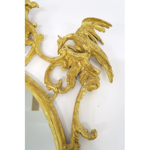 66 - A PAIR OF 19TH CENTURY GILT GESSO FRAMED OVAL WALL MIRRORSwith twinned gilt eagles mounted on foliat... 
