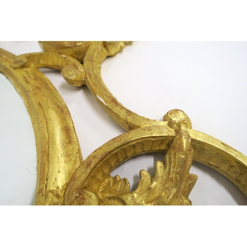 66 - A PAIR OF 19TH CENTURY GILT GESSO FRAMED OVAL WALL MIRRORSwith twinned gilt eagles mounted on foliat... 