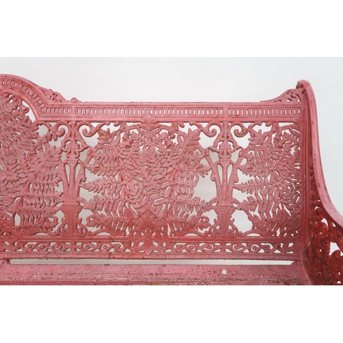 67 - A VICTORIAN CAST IRON GARDEN BENCHwith red painted sides and back cast with extensive foliate design... 