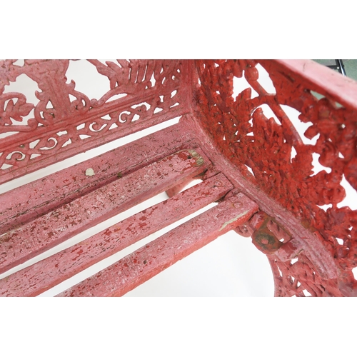 67 - A VICTORIAN CAST IRON GARDEN BENCHwith red painted sides and back cast with extensive foliate design... 