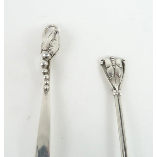 476 - A PAIR OF GEORG JENSEN SILVER PRESERVE SPOONSone in the blossom pattern, model 84, modelled with a b... 