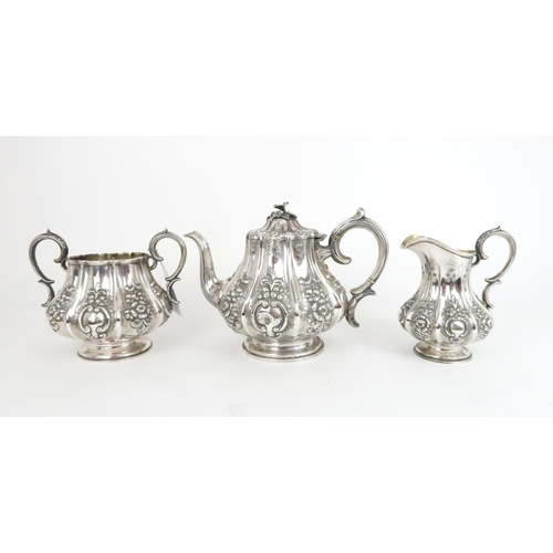 493 - A VICTORIAN THREE PIECE SILVER TEA SERVICEof lobed baluster form, the service with high repousse flo... 