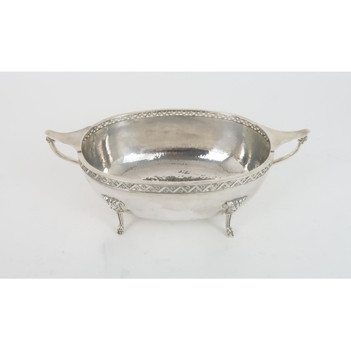 496 - A GEORGE VI TWIN HANDLED SILVER BOWLin the Arts and Crafts style, with pierced floral fretwork borde... 