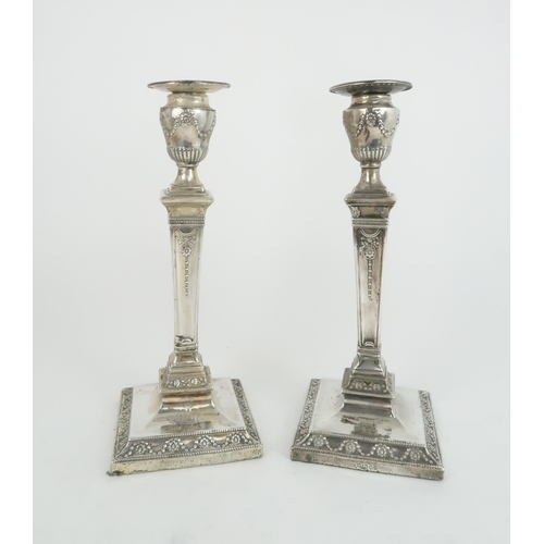 498 - A PAIR OF LATE VICTORIAN SILVER CANDLESTICKSthe circular nozzles supported by an urn on a tapering c... 