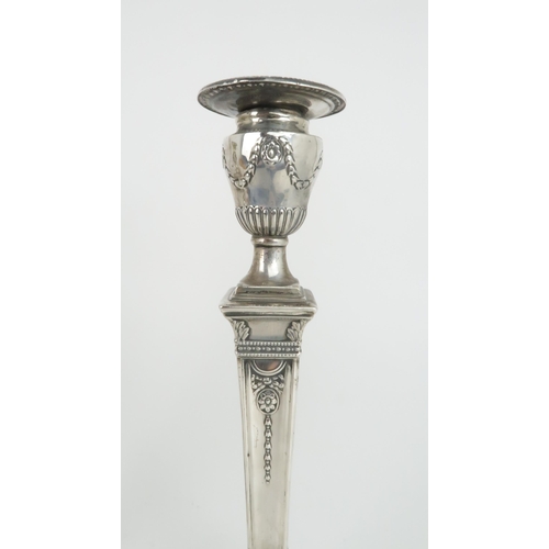 498 - A PAIR OF LATE VICTORIAN SILVER CANDLESTICKSthe circular nozzles supported by an urn on a tapering c... 