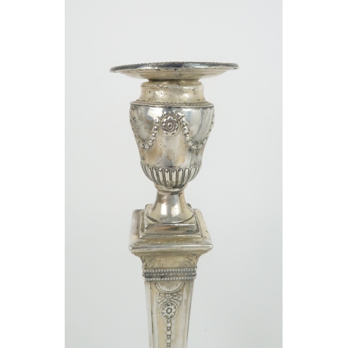 498 - A PAIR OF LATE VICTORIAN SILVER CANDLESTICKSthe circular nozzles supported by an urn on a tapering c... 