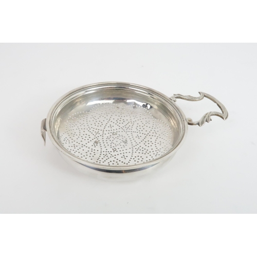 511 - A GEORGE III SILVER LEMON STRAINERthe round bowl pierced with a floral motif, with a single foliate ... 