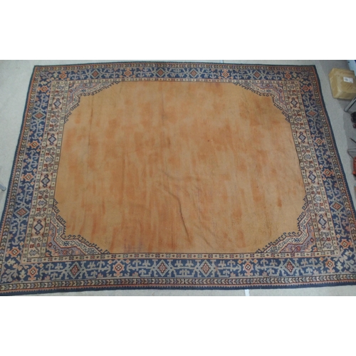 133 - A LARGE RUST GROUND MIDDLE EASTERN CARPETwith cream spandrels and blue geometric borders, 464cm long... 