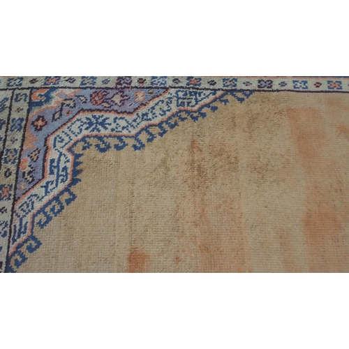 133 - A LARGE RUST GROUND MIDDLE EASTERN CARPETwith cream spandrels and blue geometric borders, 464cm long... 