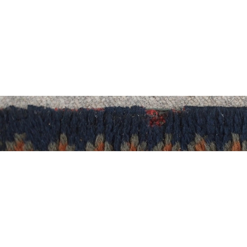 133 - A LARGE RUST GROUND MIDDLE EASTERN CARPETwith cream spandrels and blue geometric borders, 464cm long... 