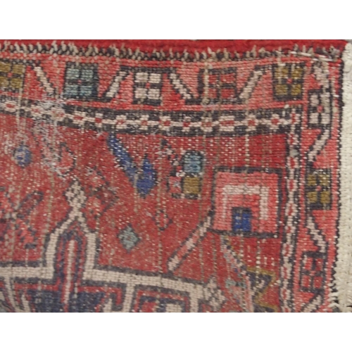 134 - A RED GROUND HERIZ RUNNERwith geometric medallions, 394cm long x 64cm wide