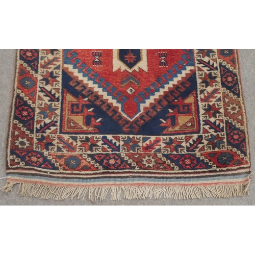 135 - A RED GROUND TURKISK DOSEMEALTI RUNNERwith multicoloured geometric medallions, dark blue spandrels a... 