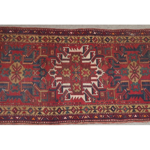 136 - A RED GROUND KARADJA RUNNERwith five geometric medallions and beige borders, 317cm long x 94cm wide... 