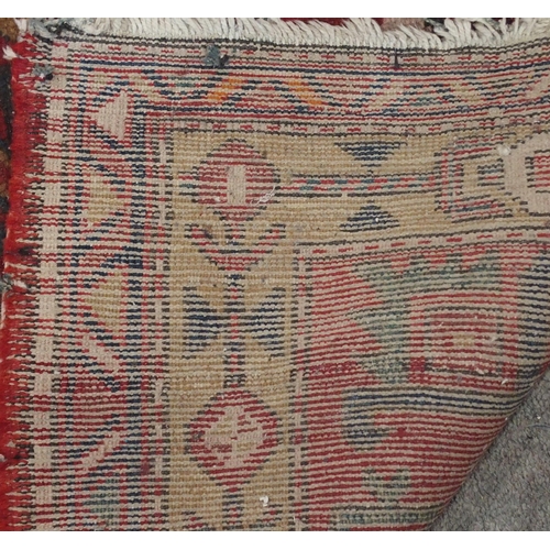 136 - A RED GROUND KARADJA RUNNERwith five geometric medallions and beige borders, 317cm long x 94cm wide... 