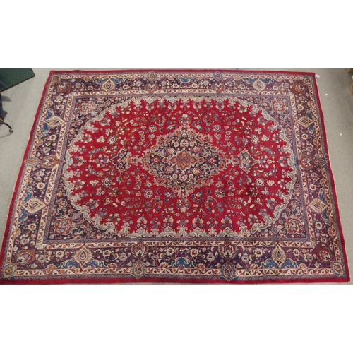 138 - A RED GROUND KESHAN RUGwith blue central medallion, matching spandrels and borders, signature to one... 