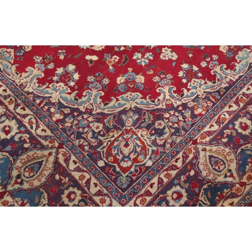 138 - A RED GROUND KESHAN RUGwith blue central medallion, matching spandrels and borders, signature to one... 