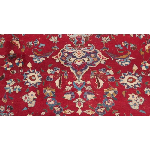 138 - A RED GROUND KESHAN RUGwith blue central medallion, matching spandrels and borders, signature to one... 