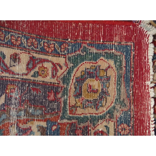 138 - A RED GROUND KESHAN RUGwith blue central medallion, matching spandrels and borders, signature to one... 