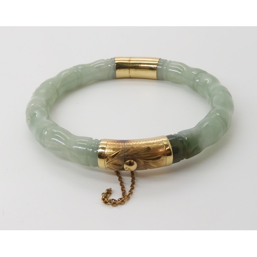 866 - A CHINESE GREEN HARDSTONE BANGLEcarved to look like bamboo, with 14k gold clasp and hinge. Inner dia... 