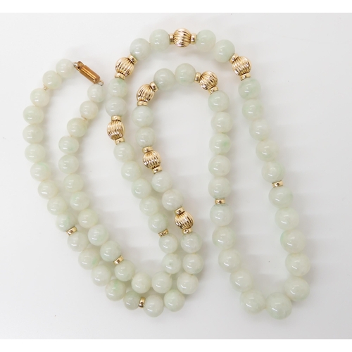 867 - A STRING OF PALE GREEN HARDSTONE BEADSwith 14k clasp and beads, length 67cm, weight 70.8gms... 