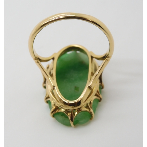 871 - AN 18CT GOLD CHINESE GREEN HARDSTONE RINGcarved with a chrysanthemum and foliage, claw set to the pi... 