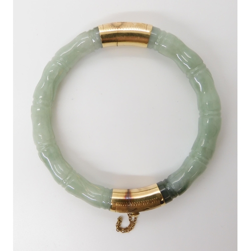 866 - A CHINESE GREEN HARDSTONE BANGLEcarved to look like bamboo, with 14k gold clasp and hinge. Inner dia... 