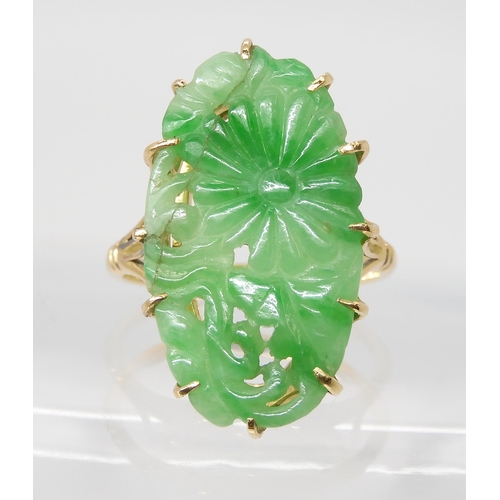 871 - AN 18CT GOLD CHINESE GREEN HARDSTONE RINGcarved with a chrysanthemum and foliage, claw set to the pi... 