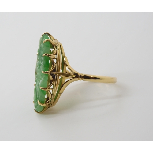 871 - AN 18CT GOLD CHINESE GREEN HARDSTONE RINGcarved with a chrysanthemum and foliage, claw set to the pi... 