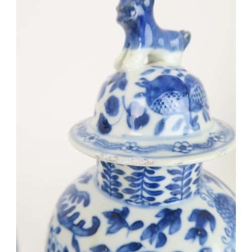 414 - A PAIR OF CHINESE BLUE AND WHITE VASES AND COVERSpainted with fruit and foliage, with shishi finials... 