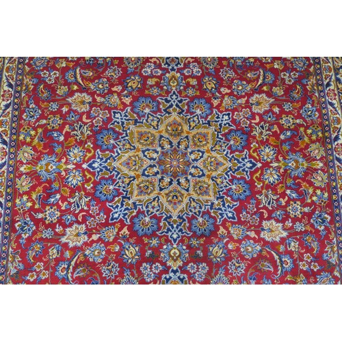 132A - A RED GROUND MESHED RUGwith floral central medallion, matching spandrels and dark blue floral border... 