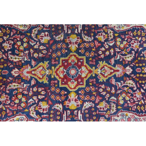 44 - A dark blue ground Persian rug with red central medallion, cream spandrels and red floral borders, 2... 