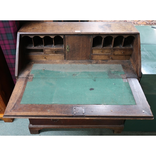 61 - A Georgian oak writing bureau with fitted fall front writing compartment above two over three drawer... 