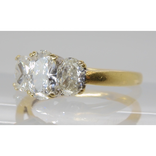 821 - AN 18CT GOLD THREE STONE DIAMOND RING