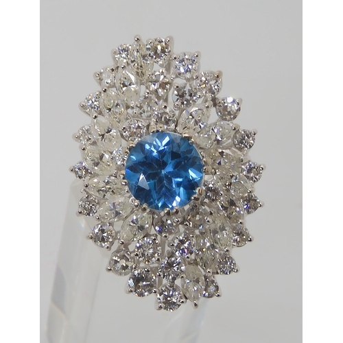 822 - A WHITE METAL DIAMOND AND BLUE TOPAZ CLUSTER RING