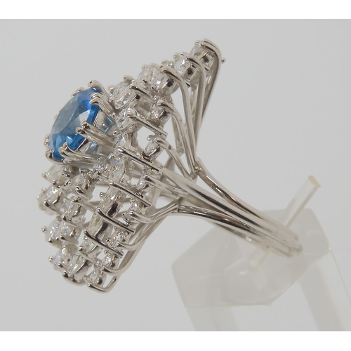 822 - A WHITE METAL DIAMOND AND BLUE TOPAZ CLUSTER RING