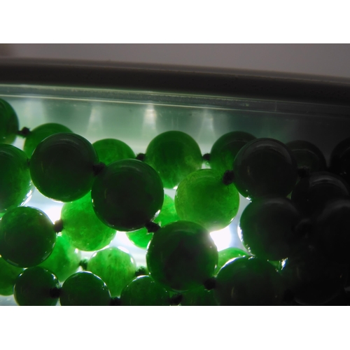 836 - A STRING OF CHINESE GREEN HARDSTONE BEADS