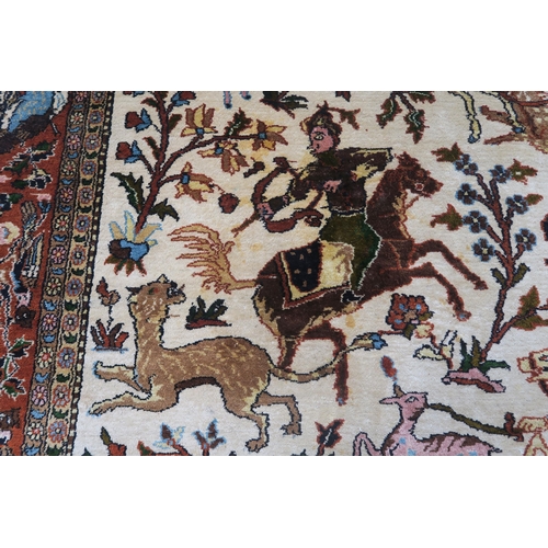 102 - AN EASTERN SILK CREAM GROUND RUG DEPICTING A HUNTING SCENE