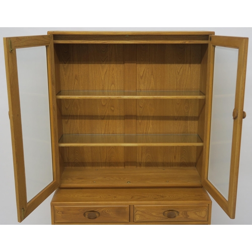 137 - AN ELM ERCOL 2149 DISPLAY CABINET ON CUPBOARD BASE